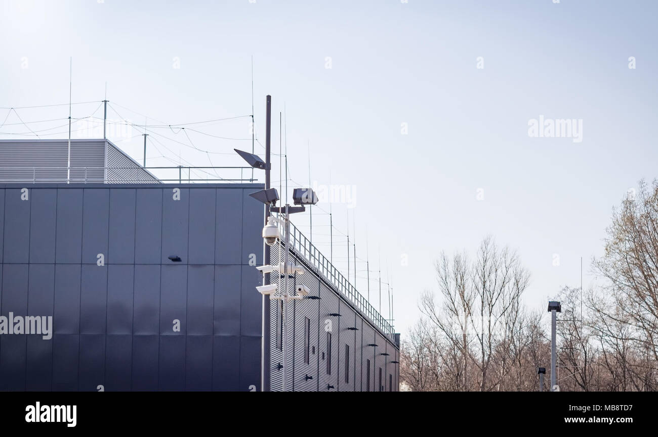 Security cameras on a pole in front of metal building Stock Photo Alamy