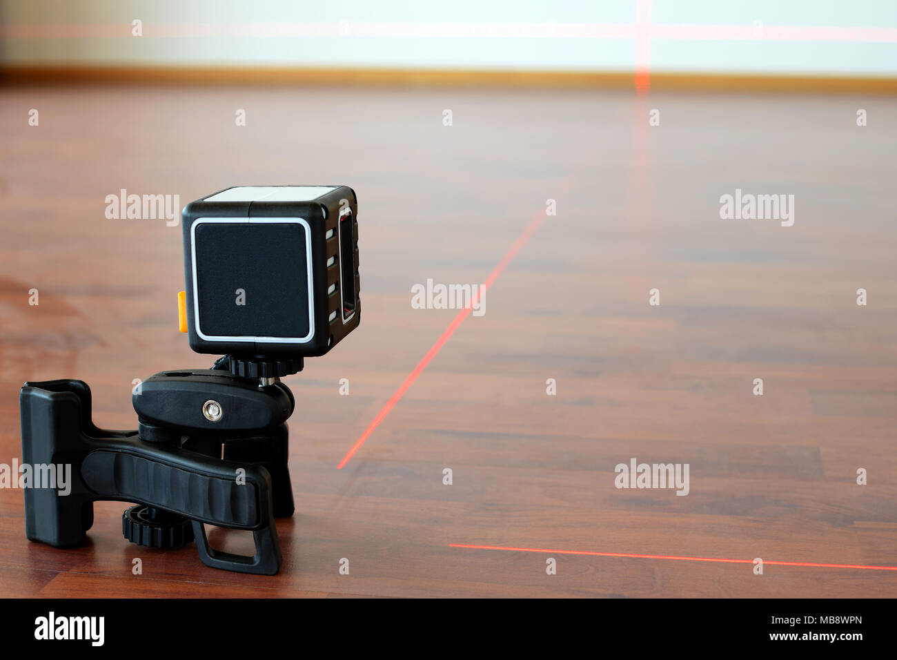 Cubic shape cross-line laser on the floor with laser lines on. Construction  and renovation concept image with room for text Stock Photo - Alamy