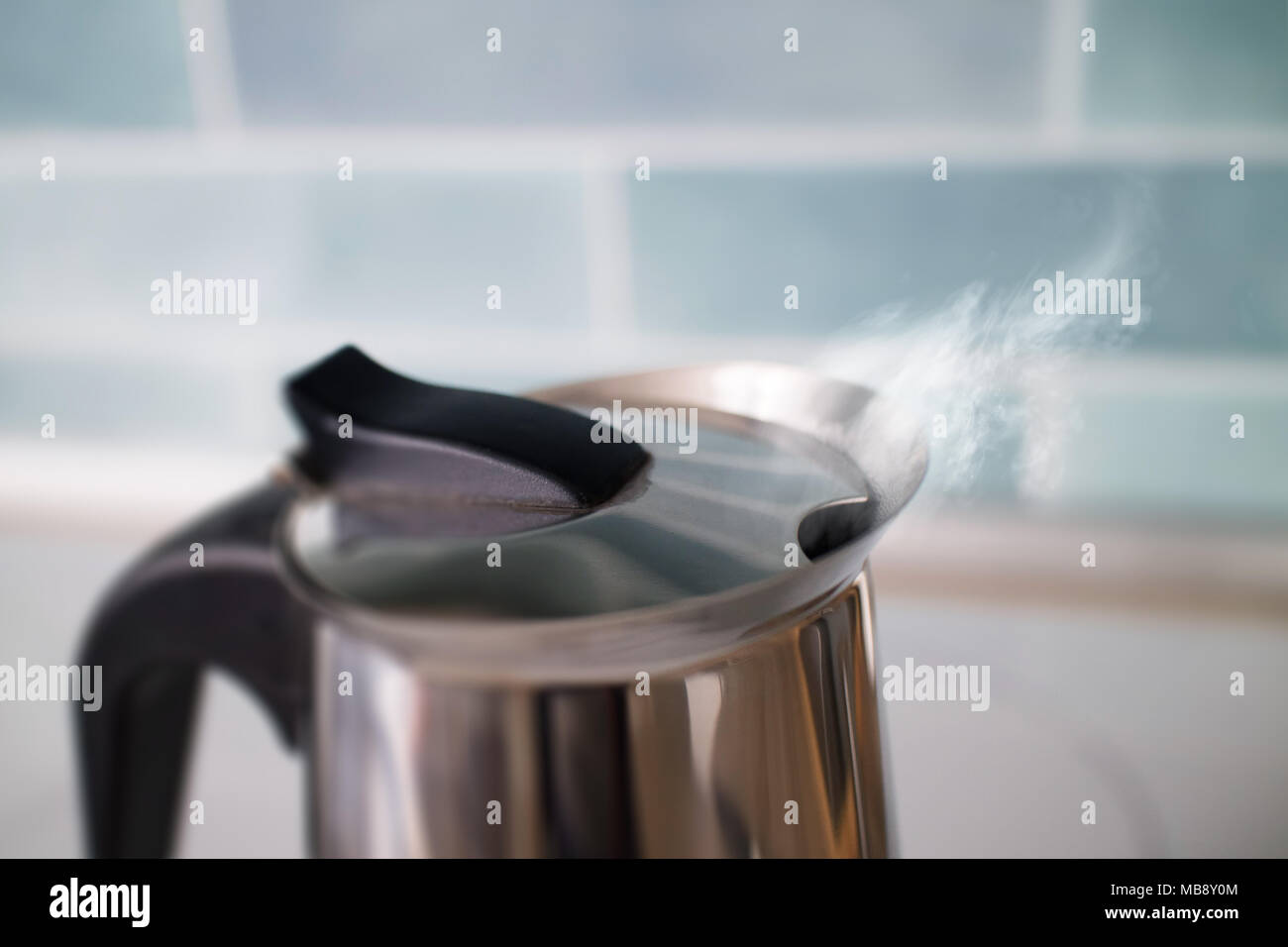 kettle with boiling hot steaming drinking water and steam Stock Photo