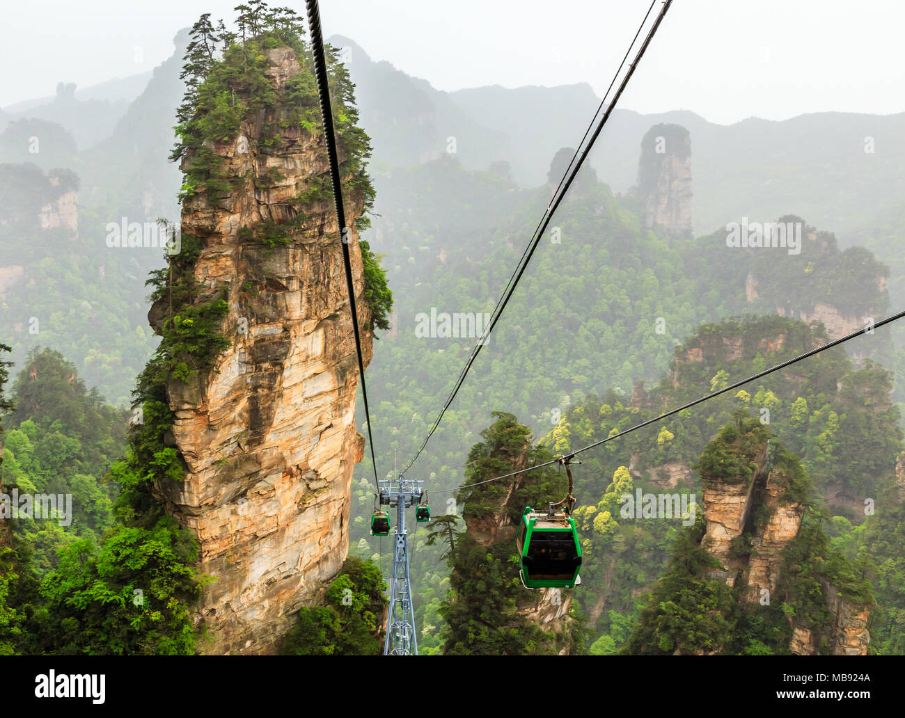 Cablecars on its way to the top among sandstone pillars and peaks with green trees and mountains panorama, Zhangjiajie national forest park, Hunan pro Stock Photo