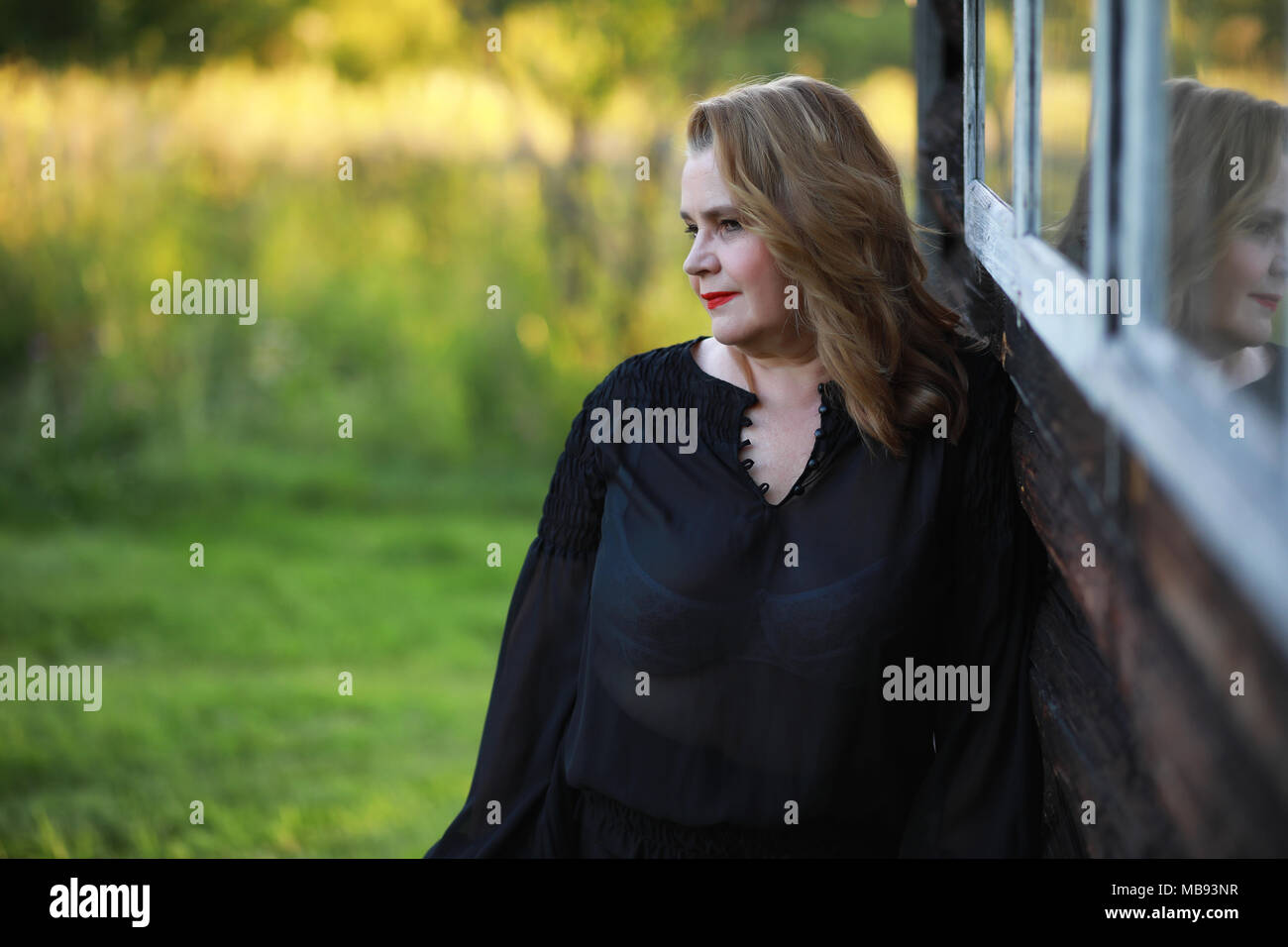 An elderly woman on the porch of a house Stock Photo - Alamy
