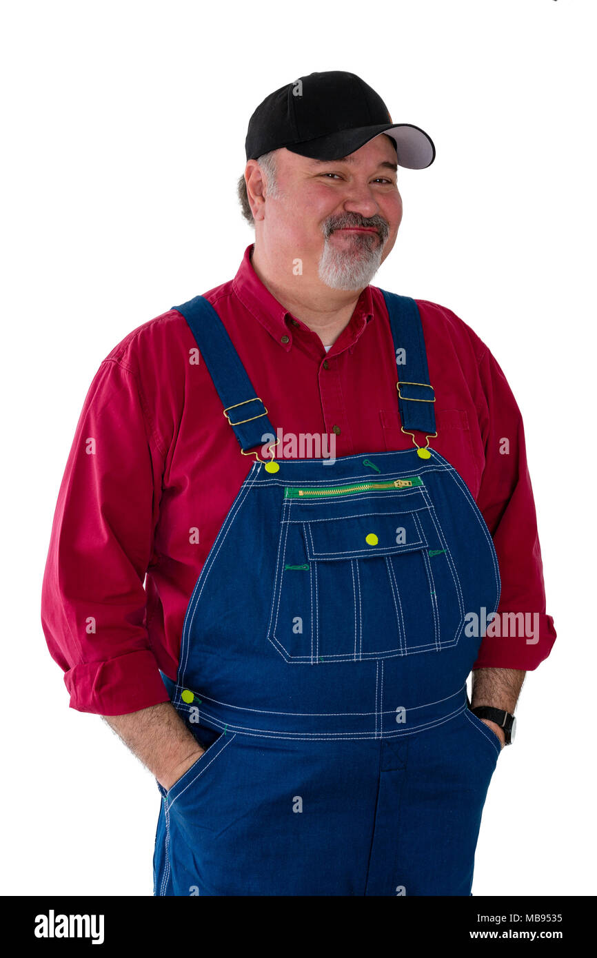 Smiling worker wearing dungarees standing against white background Stock Photo