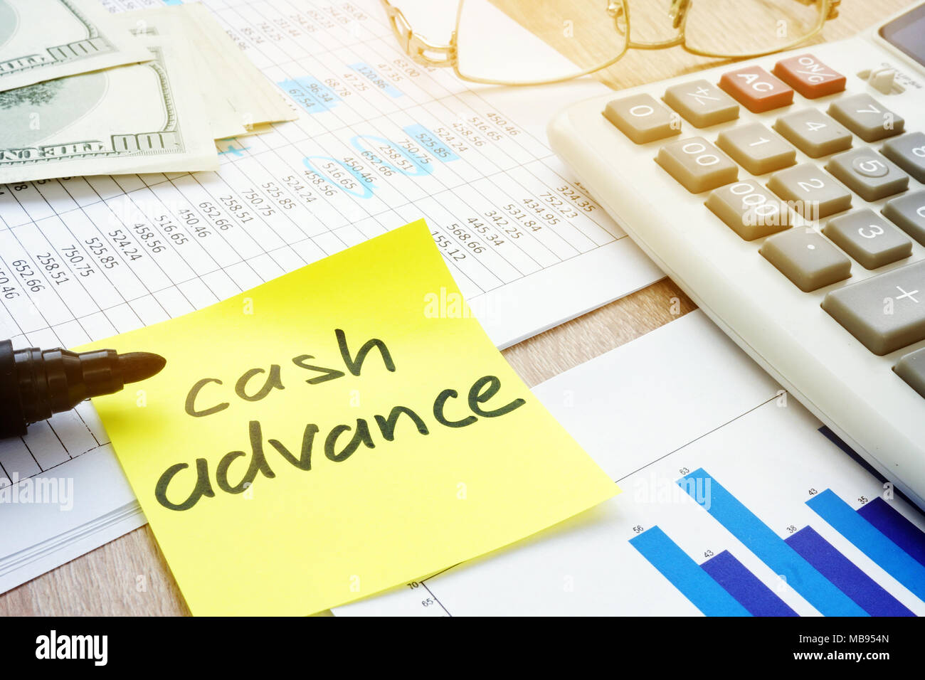 Memo stick about cash advance and calculator. Stock Photo