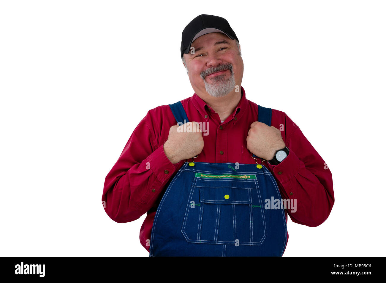 Middle-class farmer, worker, laborer or gardener standing holding the straps on his dungarees looking at the camera with a proud pleased smile isolate Stock Photo