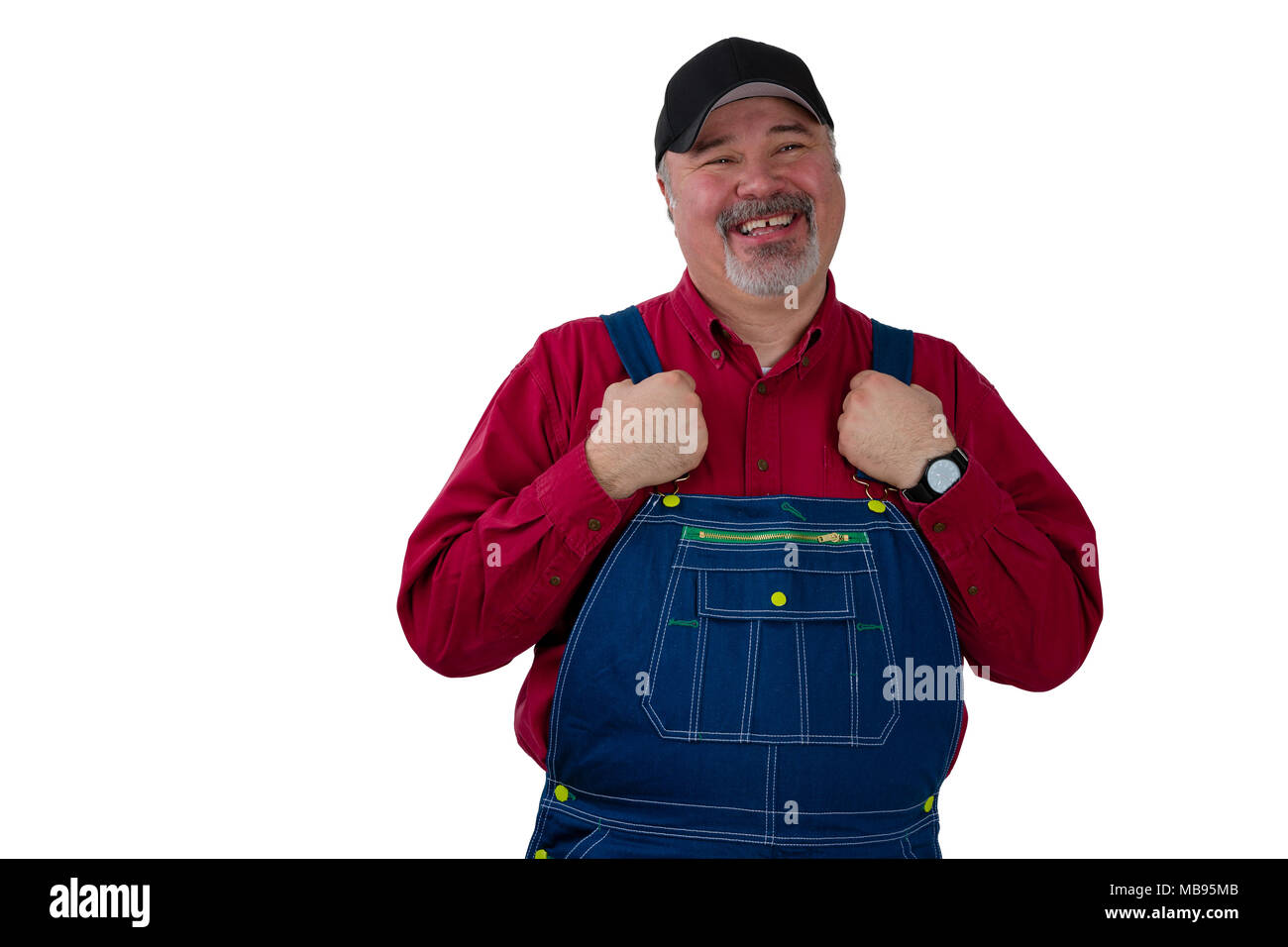 Middle-aged worker in dungarees with a proud smile holding the straps of his overalls as he grins at the camera isolated on white Stock Photo