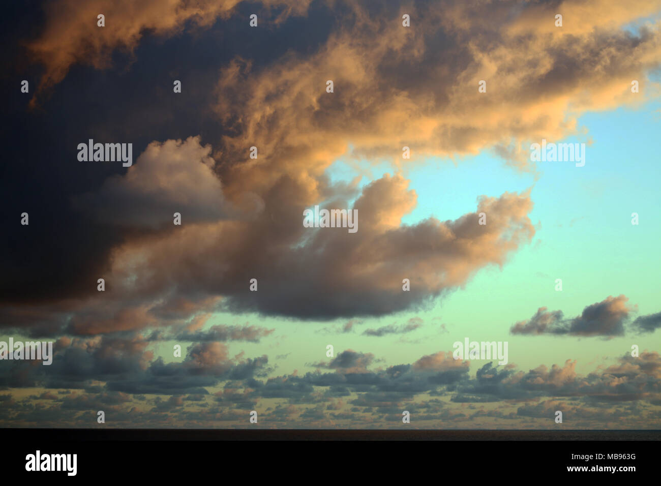 early morning dark clouds with greenish blue sky peeking out Stock Photo