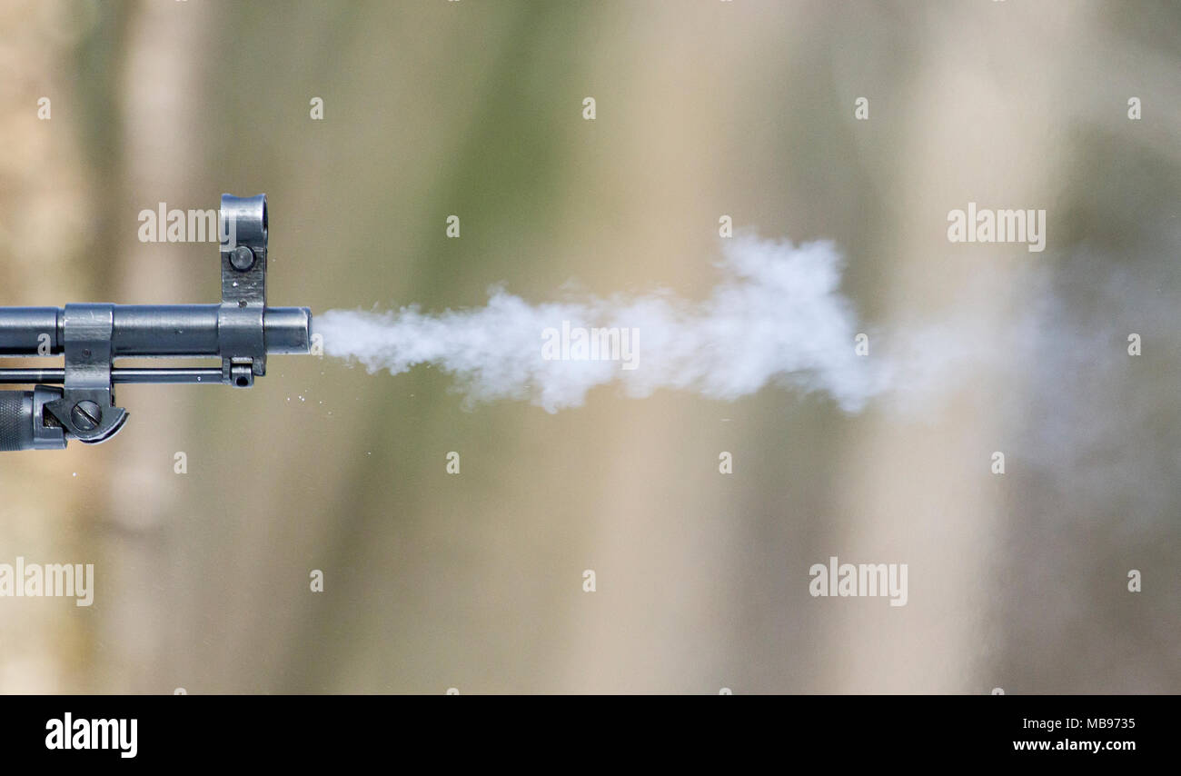 Smoke leaving the barrel as a gun is fired Stock Photo