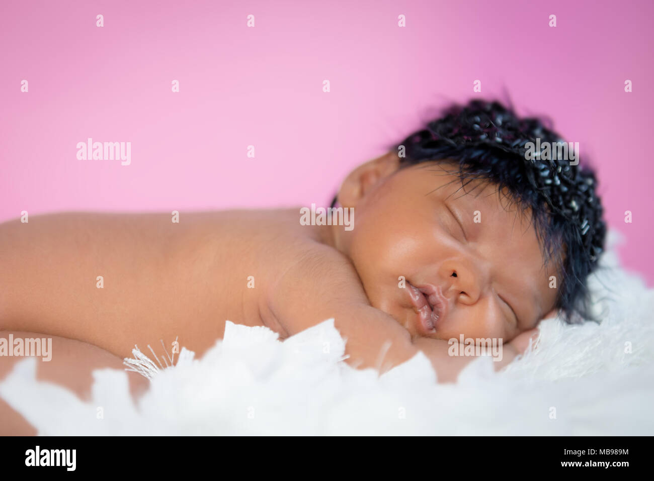 Cute Baby Sleeping on fluffy mat pink background Stock Photo