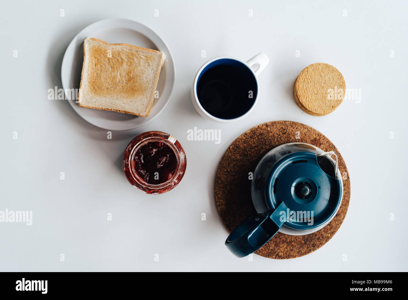 Lay flat of breakfast with coffee, biscuits and toast with jam on white table Stock Photo