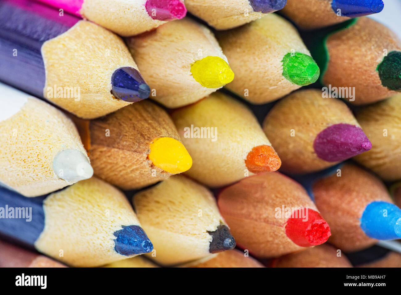 A close up shot of a tightly packed group of coloured pencils shot from the sharp end. All the pencils have all been freshly sharpened. Stock Photo