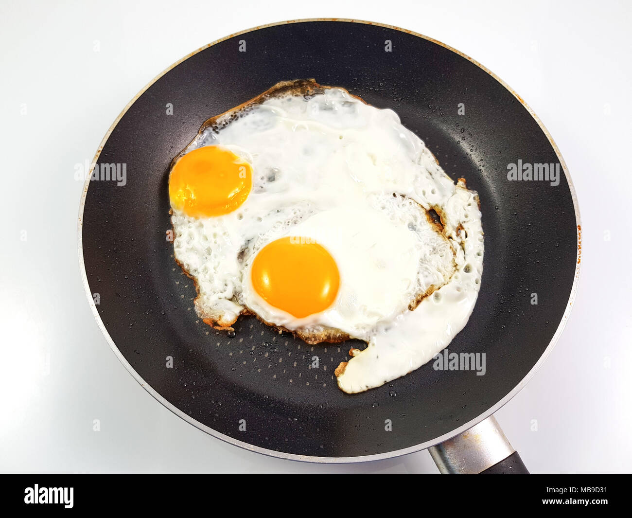 Fried eggs in pan with isolated white background, top view Stock Photo ...