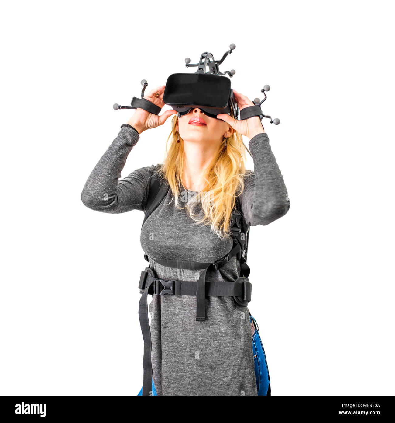 Beautiful woman in vr. She wearing Virtual reality glasses or goggles on forehead, processor in backpack on back and sensors for tracking on head and  Stock Photo