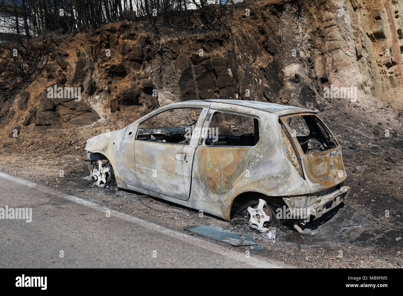 Wreck of a burnt out car caused by forest fires in the neighborhood of ...