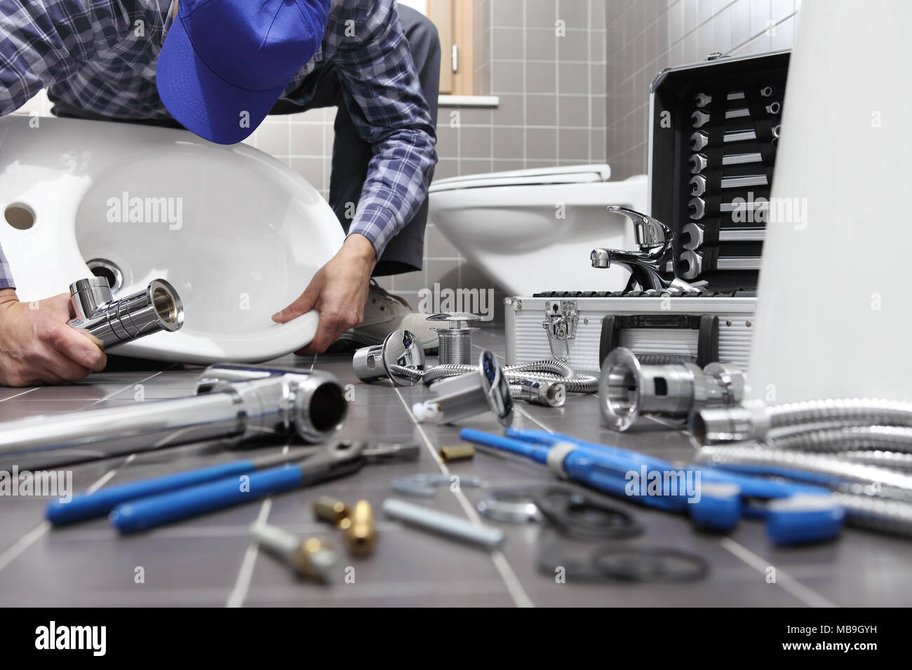 plumber at work in a bathroom, plumbing repair service, assemble and