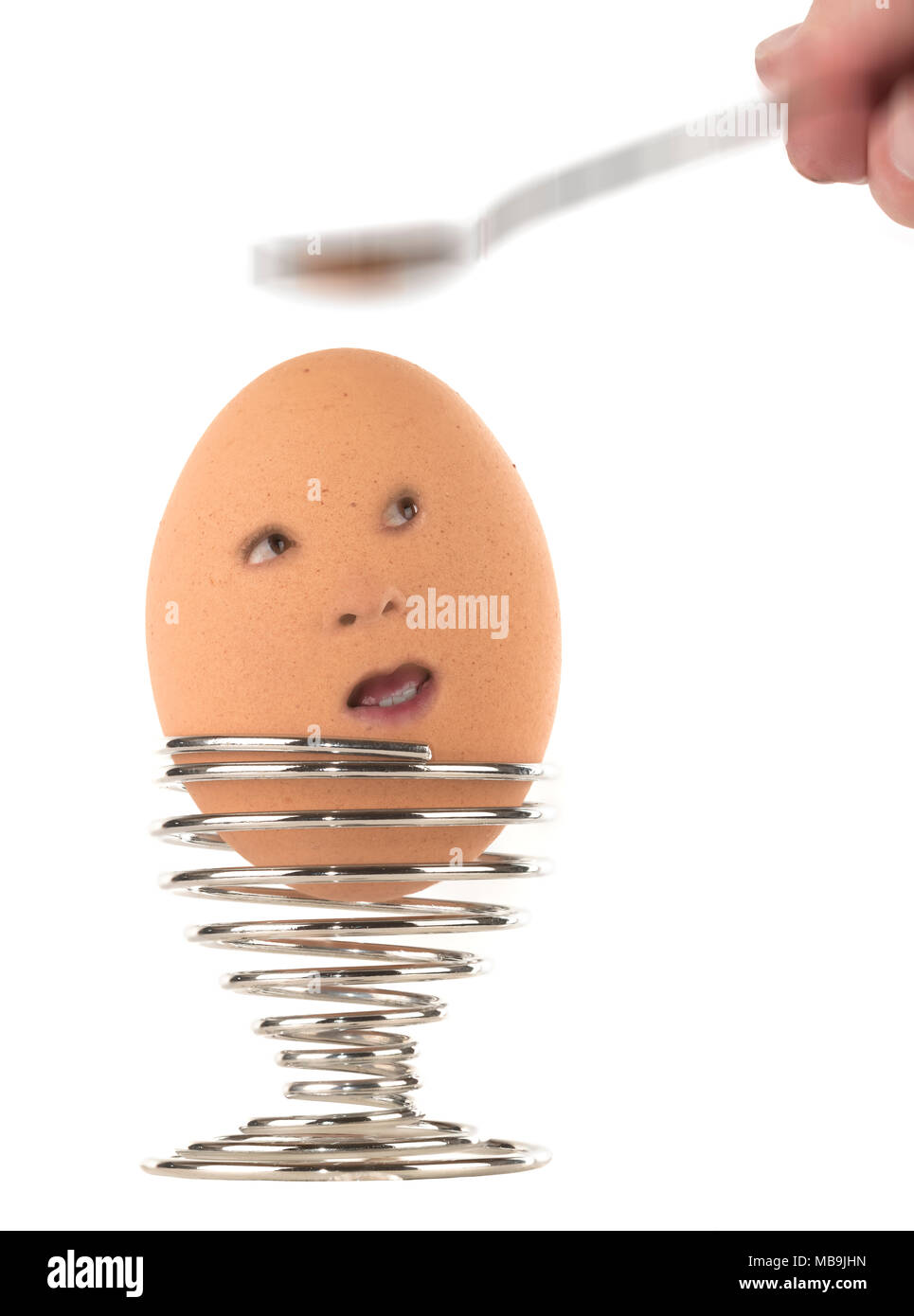 cracking / breaking egg with face with a spoon Stock Photo