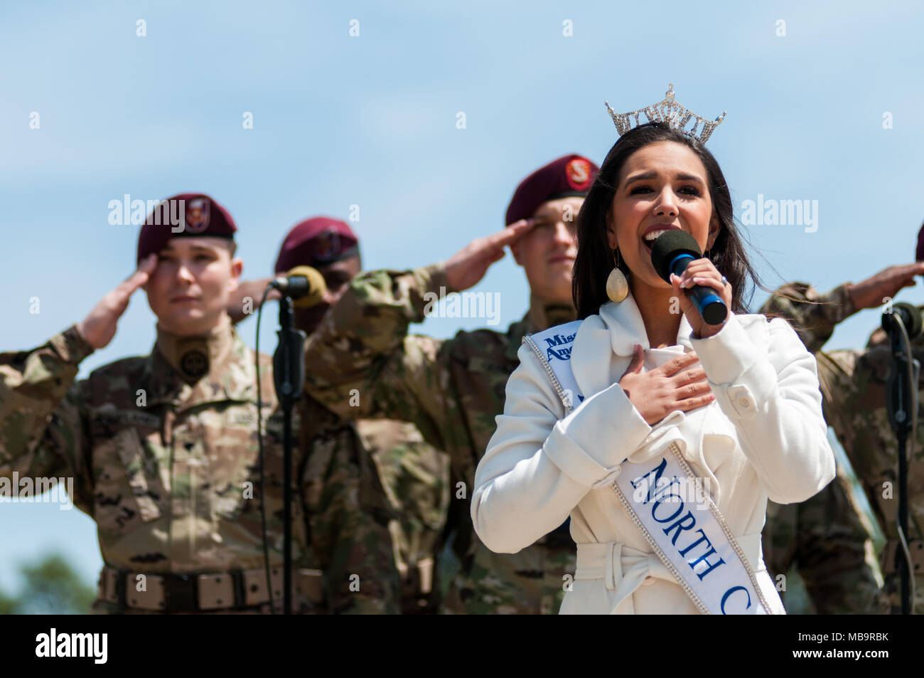 Pinehurst, North Carolina, USA. 8th Apr, 2018. April 8, 2018 - Pinehurst, N.C., USA - Miss North Carolina Victoria Huggins, sings the national anthem in front of the 82nd Airborne Division All American Chorus at the 69th annual Spring Matinee Harness races sponsored by the Pinehurst Driving & Training Club, at the Pinehurst Harness Track, Pinehurst, N.C. The Pinehurst Harness Track is a 111-acre equestrian facility that has been a winter training center for standardbred horses since 1915. This year's races commemorate the 103rd anniversary of the track. (Credit Image: © Timothy L. Hale via Z Stock Photo