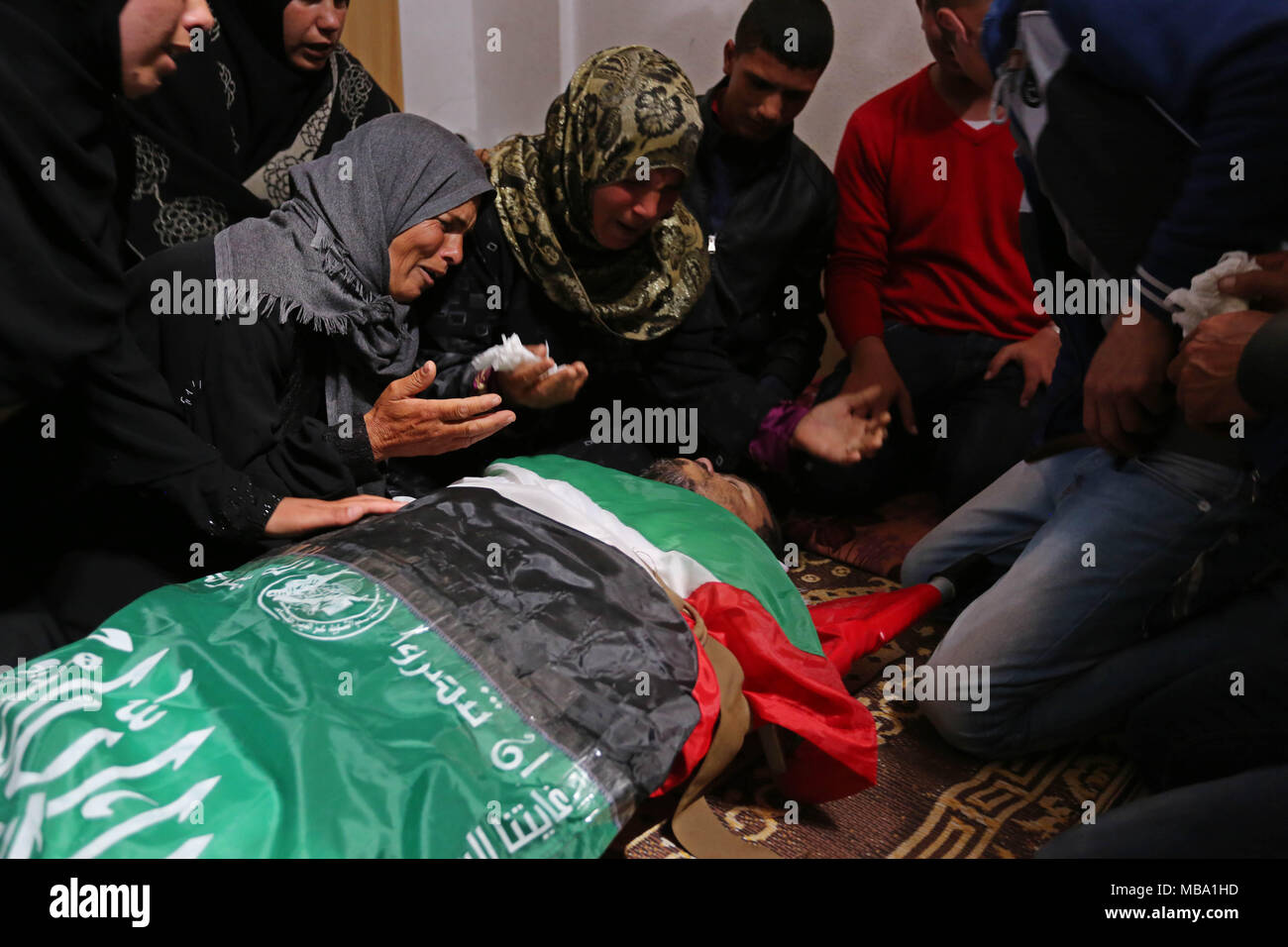 Khan Yunis, Gaza Strip, Palestinian Territory. 9th Apr, 2018. Palestinian relatives of Marwan Qudeih, who was wounded by Israeli fire east of Khan Yunis on March 30 and later died of his wounds, mourn over his body during his funeral in Khan Yunis, in the southern Gaza Strip on April 9, 2018 Credit: Ashraf Amra/APA Images/ZUMA Wire/Alamy Live News Stock Photo