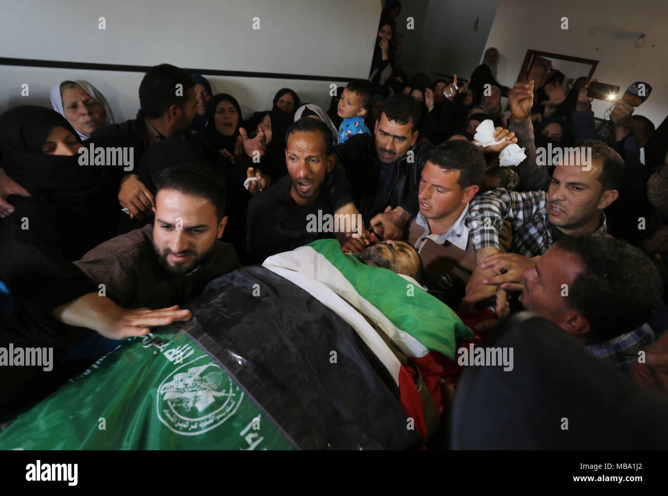 Khan Yunis, Gaza Strip, Palestinian Territory. 9th Apr, 2018. Palestinian relatives of Marwan Qudeih, who was wounded by Israeli fire east of Khan Yunis on March 30 and later died of his wounds, mourn over his body during his funeral in Khan Yunis, in the southern Gaza Strip on April 9, 2018 Credit: Ashraf Amra/APA Images/ZUMA Wire/Alamy Live News Stock Photo