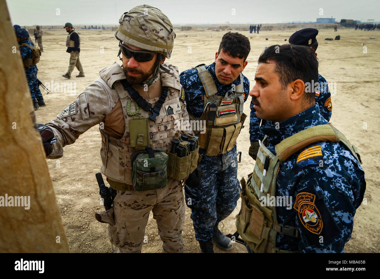 A Spanish trainer goes over shot groups with Iraqi soldiers attached to ...