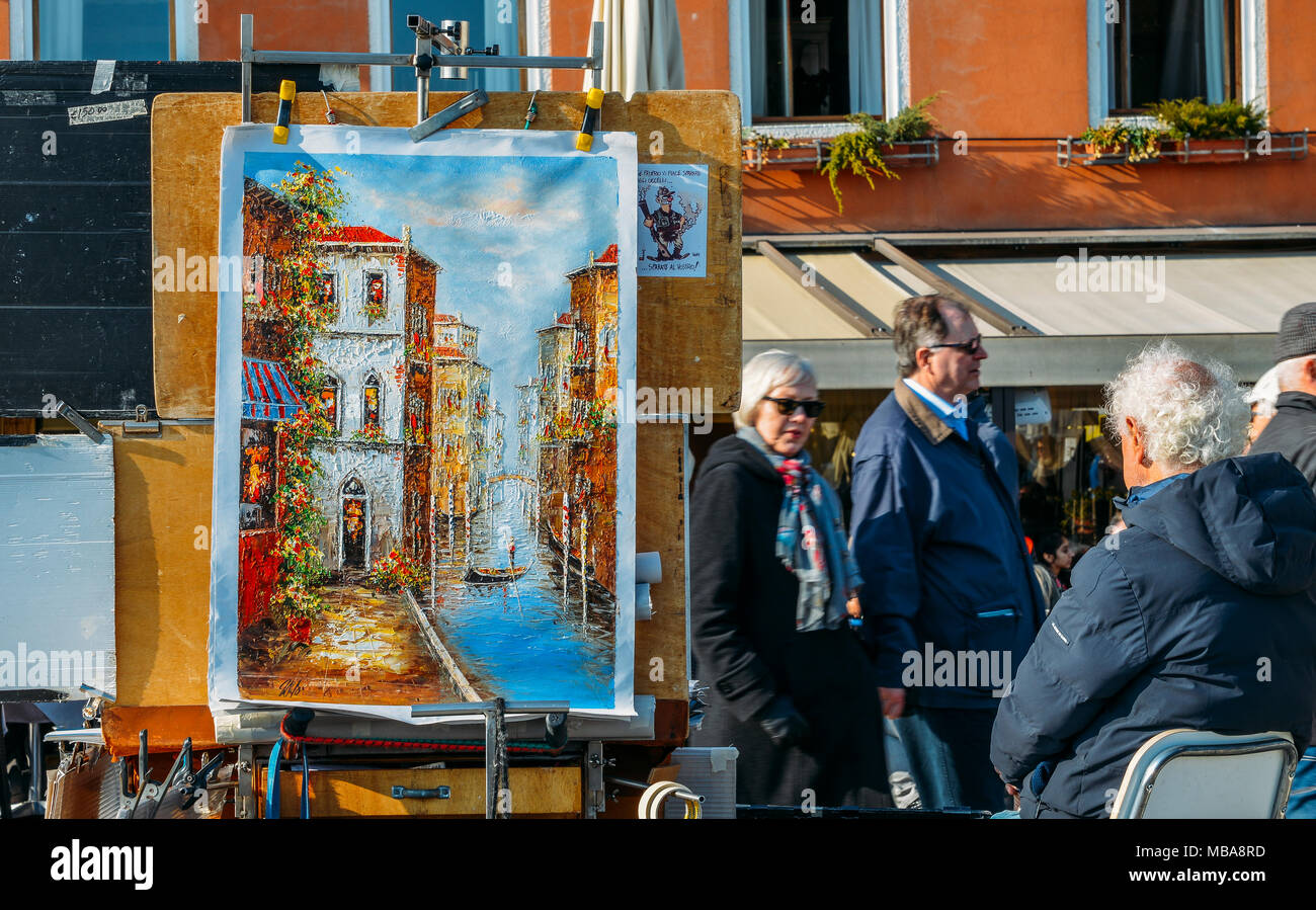 Unknown artist sells paintings on the waterfront in Venice. Tourists