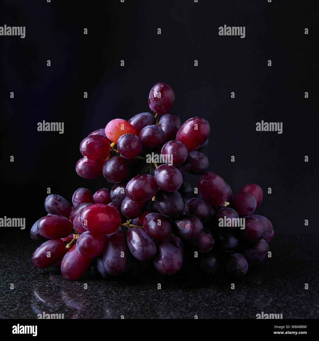 Red seedless grapes on black background Stock Photo Alamy