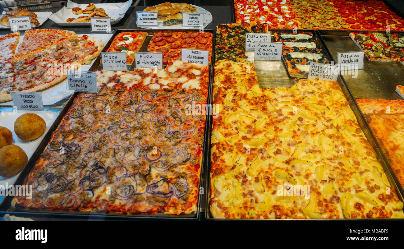 Various flavours of different pizzas, with Italian descriptions, for sale on a shop front window in Venice Stock Photo