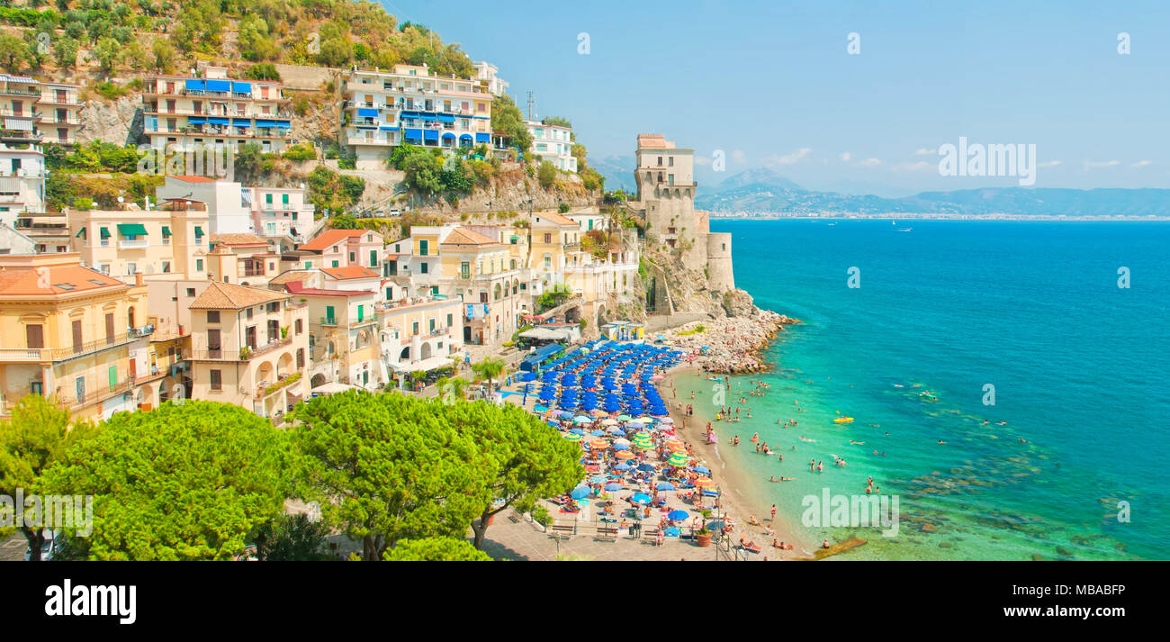 panoramic view of small town and beach full of relaxing people on hot summer day by mediterranean sea on Amalfi coast in Cetara, Salerno, Campania, It Stock Photo