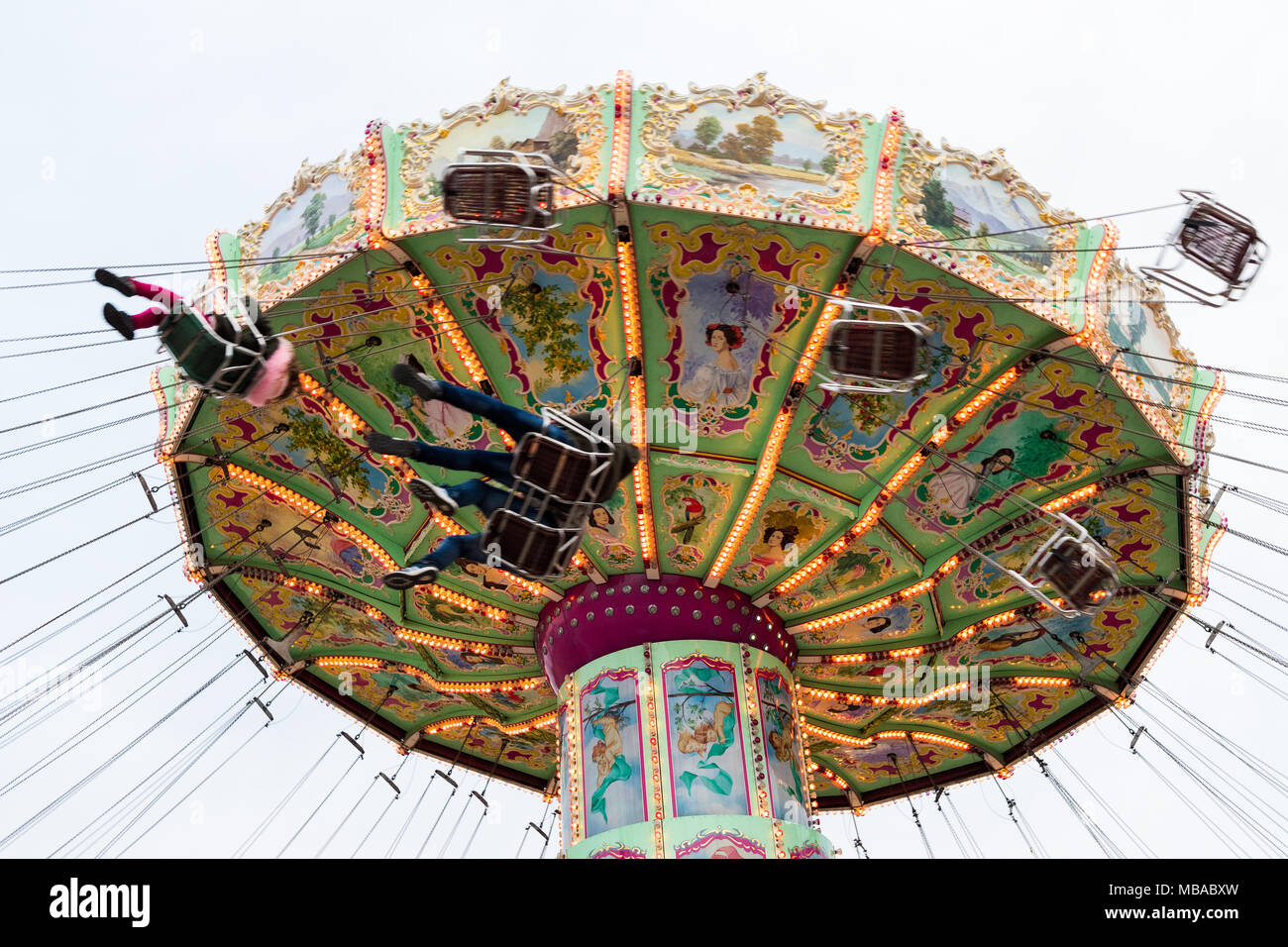 Low angle view of the moving Luftikus carousel or chain swing ride at overcast day, Prater amusement park Stock Photo