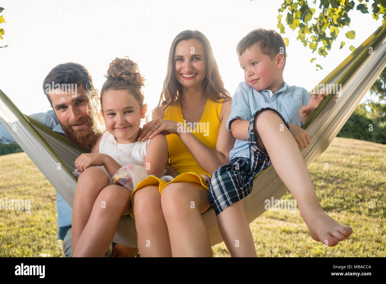 Family portrait with beautiful mother of two children next to her husband Stock Photo