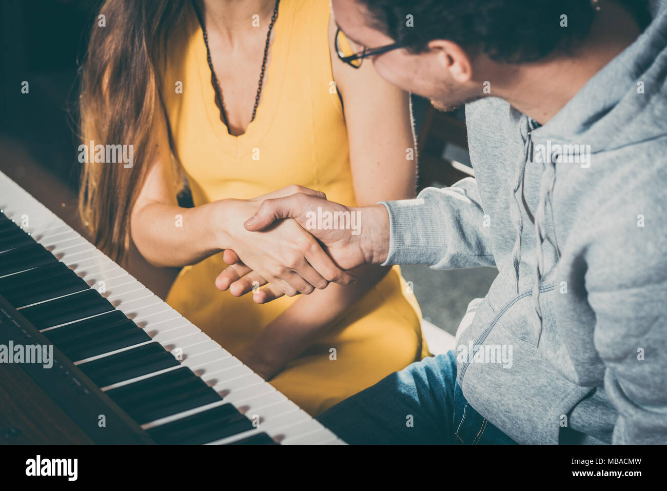 Piano teacher and student shaking hands after lesson Stock Photo