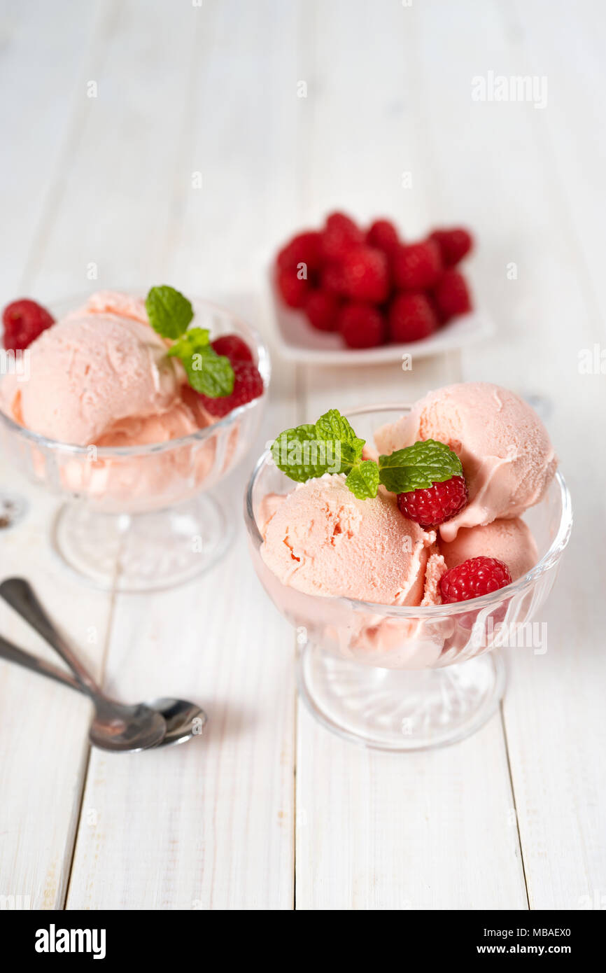 https://c8.alamy.com/comp/MBAEX0/vertical-studio-shot-of-raspberry-ice-cream-in-glass-dishes-on-white-wooden-table-MBAEX0.jpg