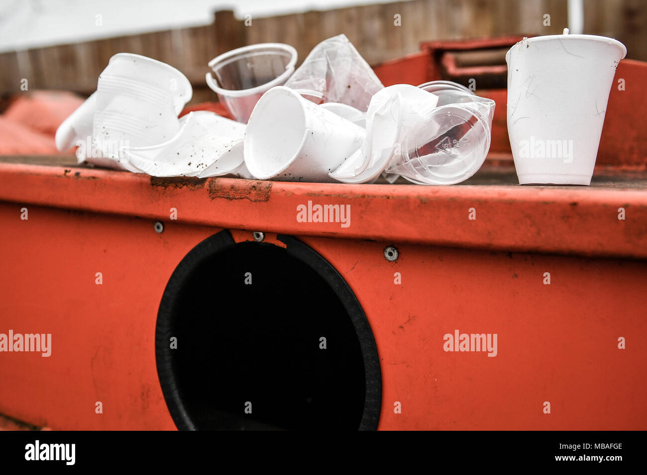Disposable drinking cups sit on a plastic recycling centre mixed
