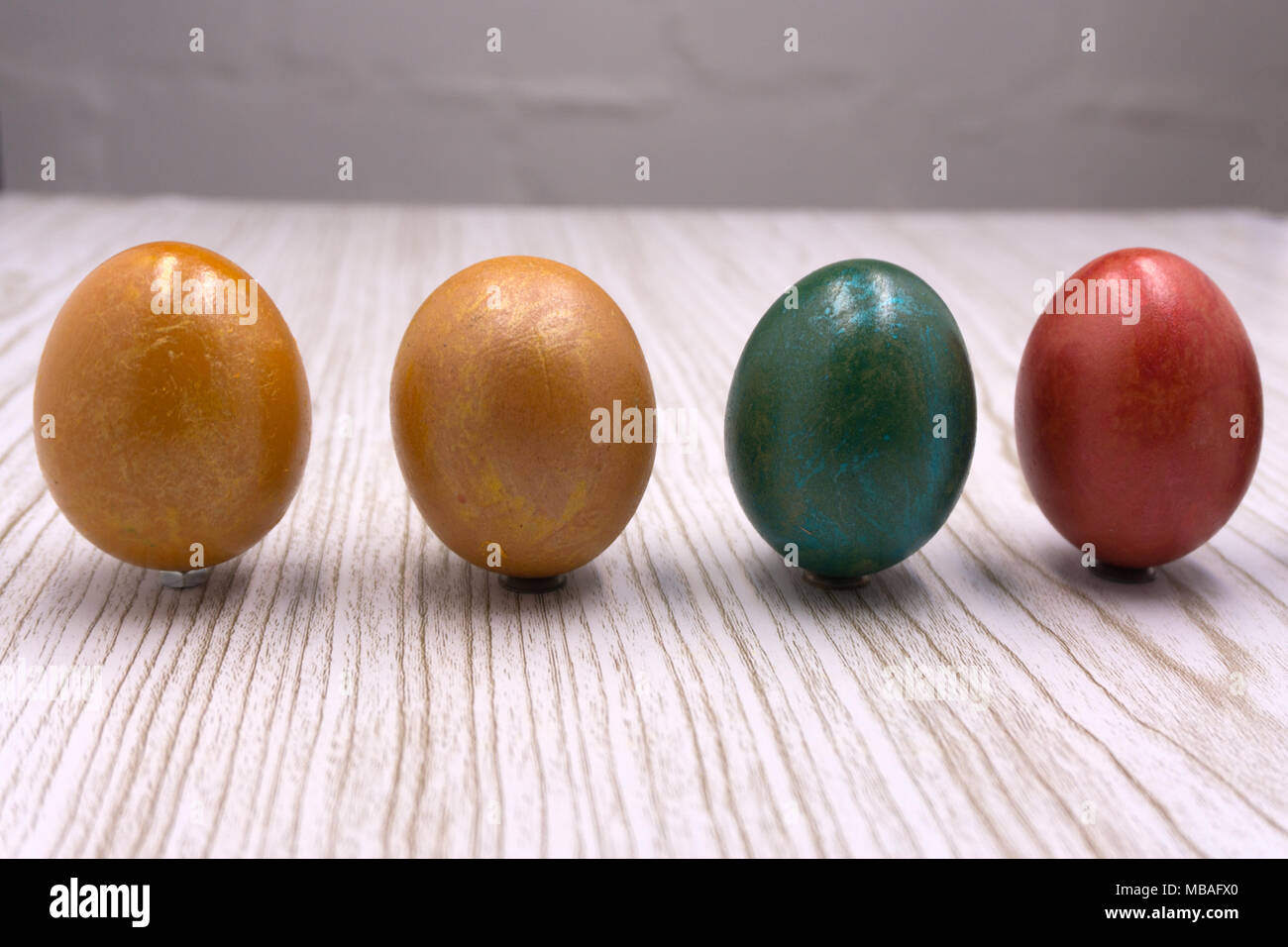 Multi-colored eggs on the nest with orange light side for easter holiday background Stock Photo
