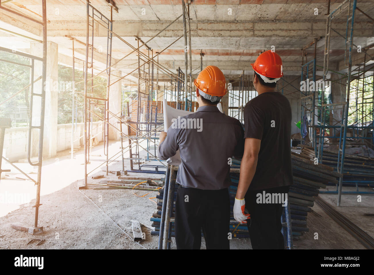 Engineer discussing with foreman about project in building construction site Stock Photo