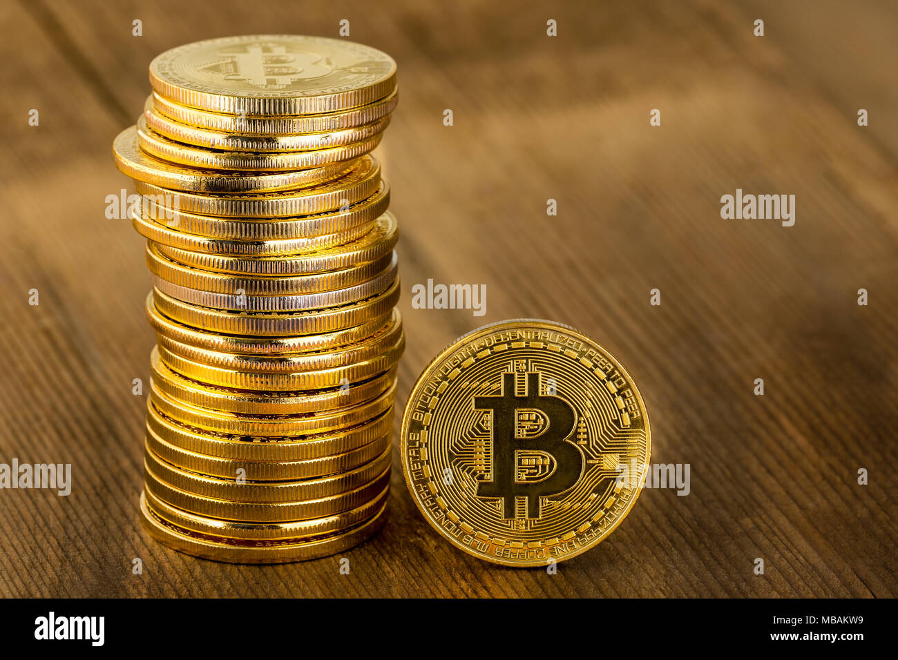 Single gold Bitcoin coin standing upright alongside a stacked pile in a  concept of a digital or virtual cryptocurrency, online finances, and  investmen Stock Photo - Alamy