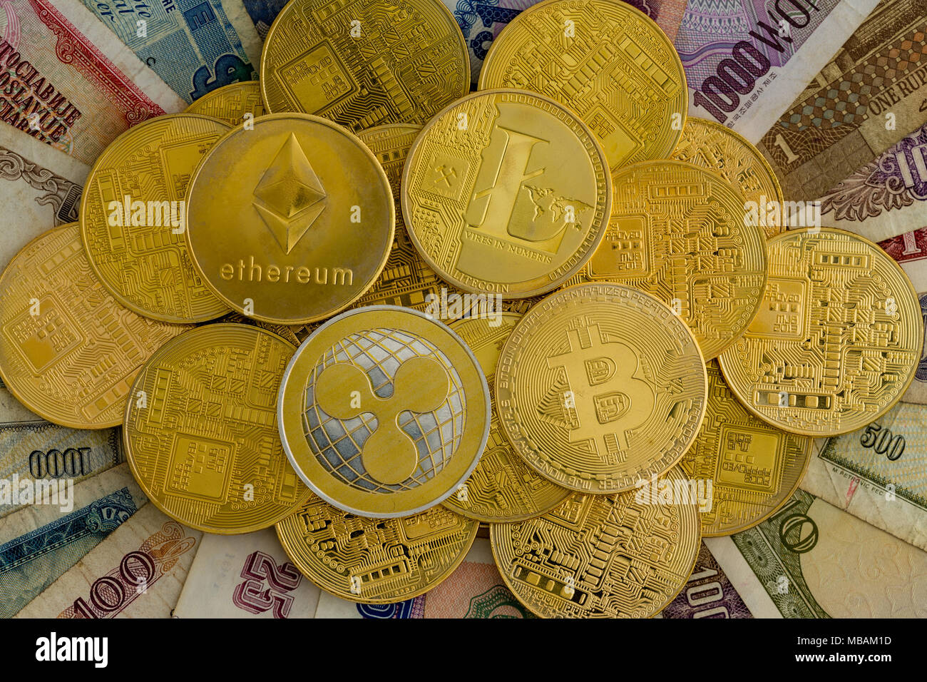 Pile of assorted gold cryptocurrency coins on a background of old worldwide  paper currency banknotes viewed from above in a concept of digital finance  Stock Photo - Alamy