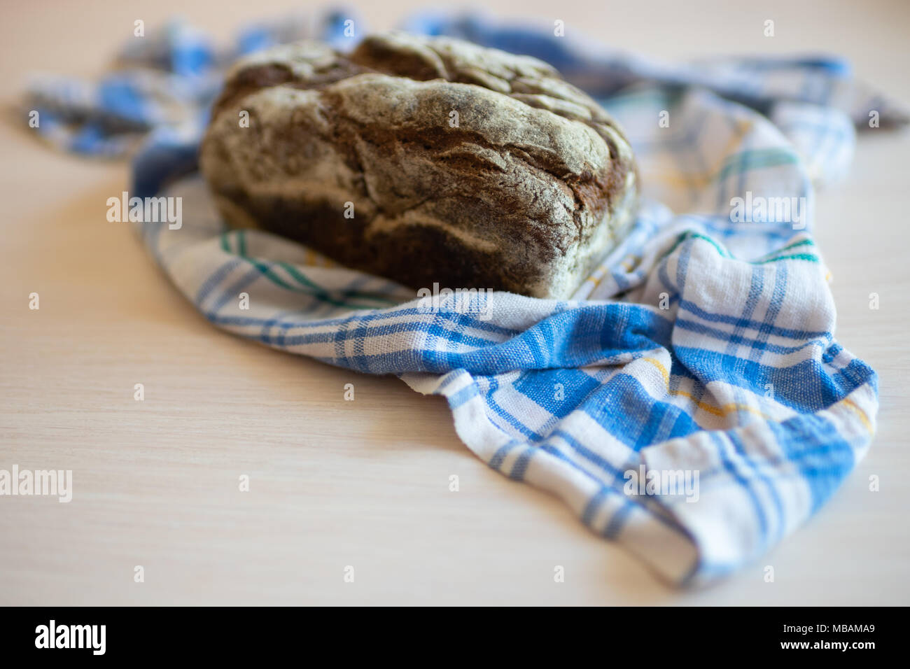 Brown bread on a table with a plaid towel Stock Photo