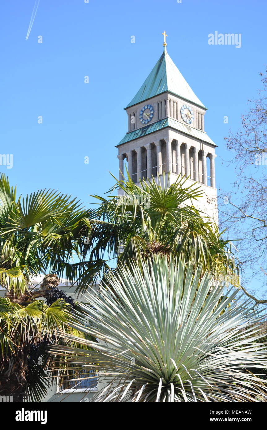 Clock tower over palm trees, Frankfurt Zoo, Germany Stock Photo