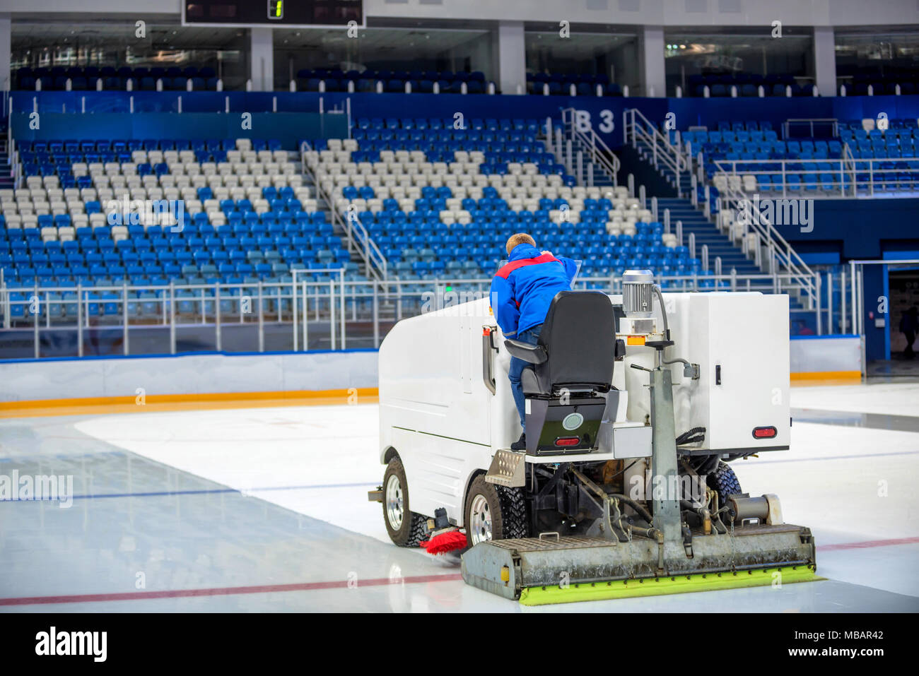 Resurfacing machine cleans ice of hockey rink Stock Photo