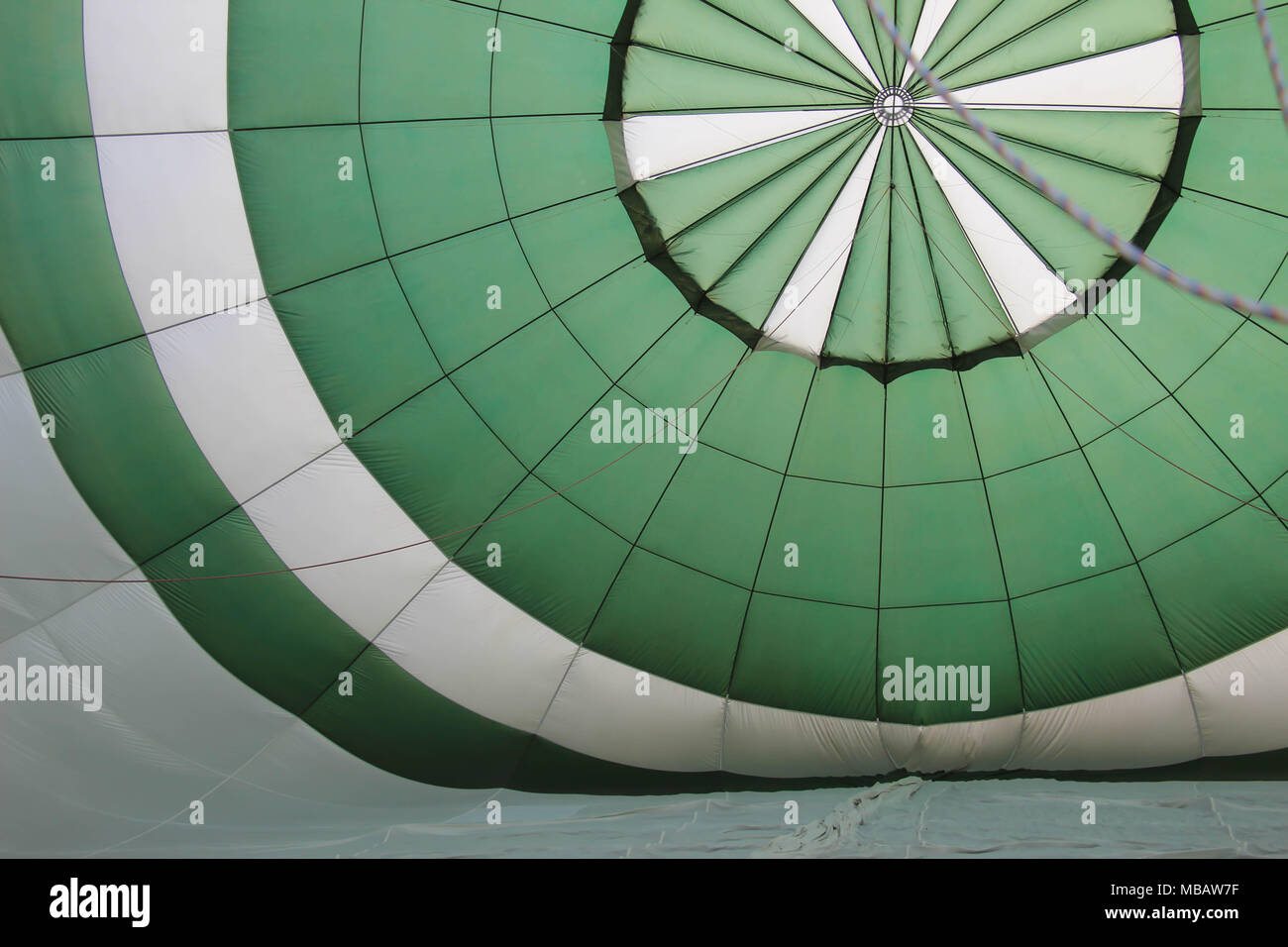 inside of a green and white hot air balloon as it inflates Stock Photo