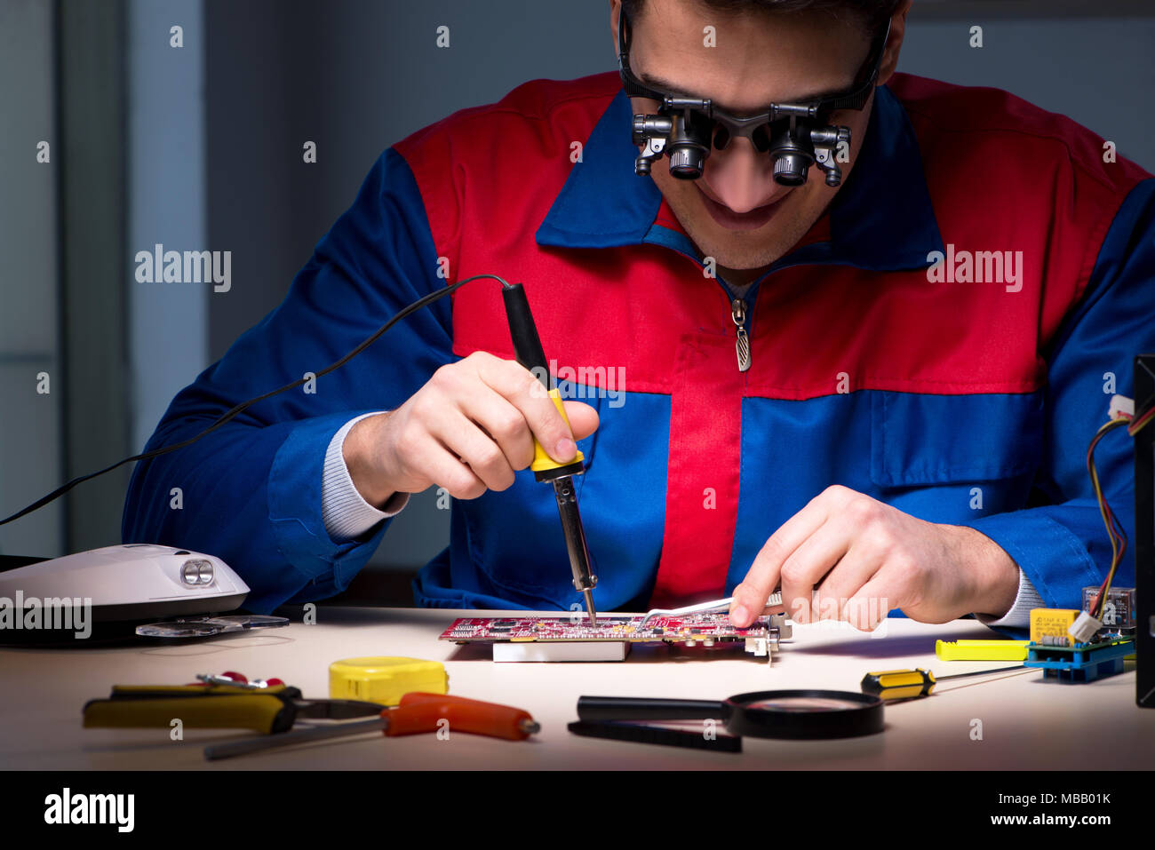 Computer specialist repairing PC late at night Stock Photo - Alamy