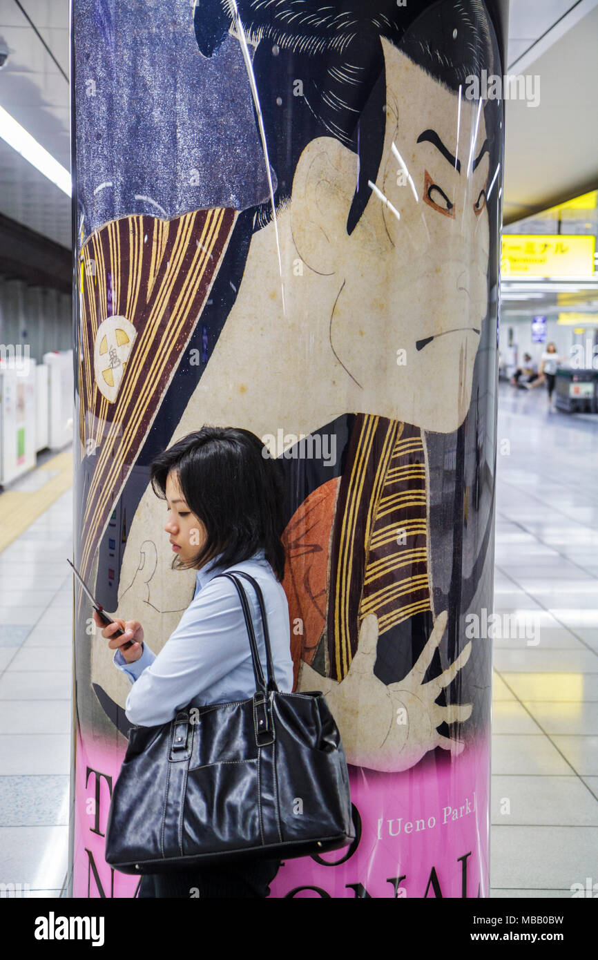 Tokyo Japan,Haneda Airport,Keikyu Line,train,subway,train,train,station,Asian Oriental,woman female women adult adults,cell phone phones checking look Stock Photo