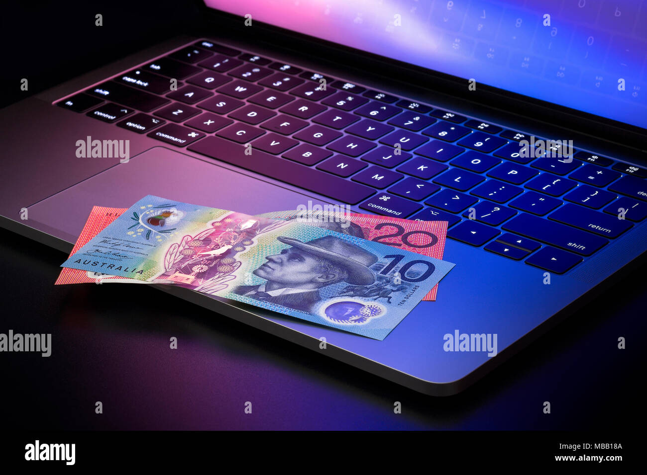 Two Australian dollar banknotes on laptop, 10 dollar and 20 dollar notes Stock Photo