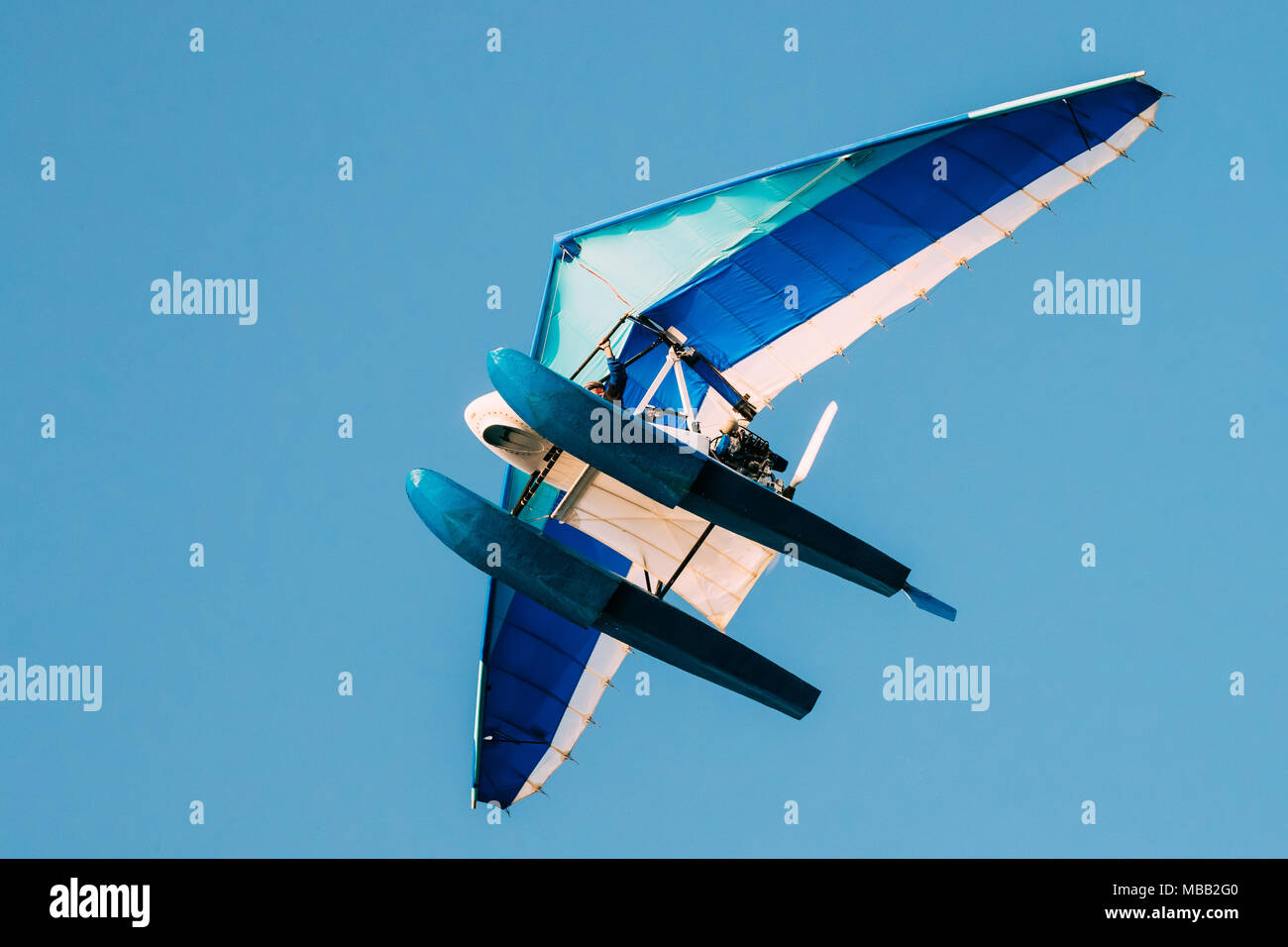 Motorized Hang Glider Flying On Blue Clear Sunny Sky Background. Stock Photo