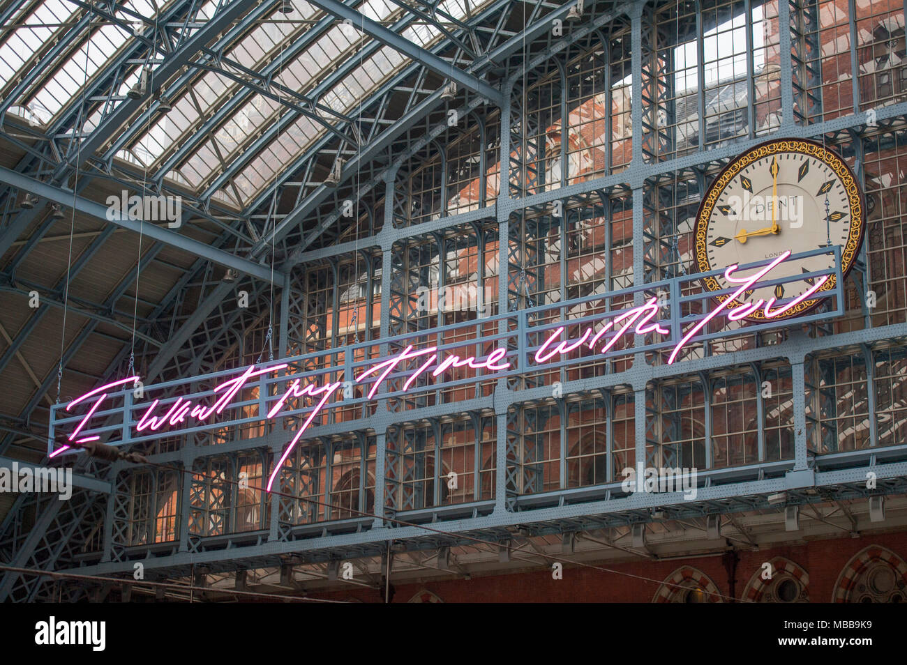 St Pancras station, London, UK. 10 April 2018. In celebration of the 150th anniversary of St Pancras International and the 250th anniversary of the RA, Tracey Emin CBE RA presents a free public Terrace Wires installation suspended from the station’s Victorian glass roof. The largest text piece she has ever made at 20 metres long reminds travellers to stop and take a moment in one of the UK’s busiest railway stations. I Want My Time With You hangs directly below the St Pancras clock. Credit: Malcolm Park/Alamy Live News. Stock Photo