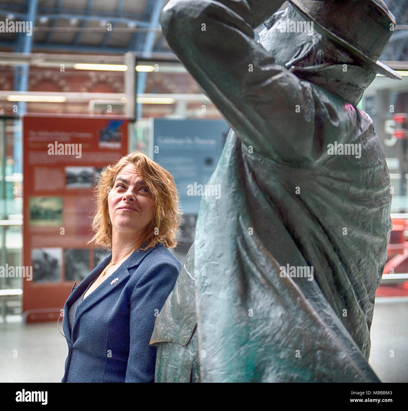 St Pancras International station, London, UK. 10 April 2018. In celebration of the 150th anniversary of St Pancras International and the 250th anniversary of the RA, Tracey Emin CBE RA presents a free public Terrace Wires installation suspended from the station’s Victorian glass roof. Photo: Tracy Emin looking at The Betjeman Statue by Martin Jennings. Credit: Malcolm Park/Alamy Live News. Stock Photo