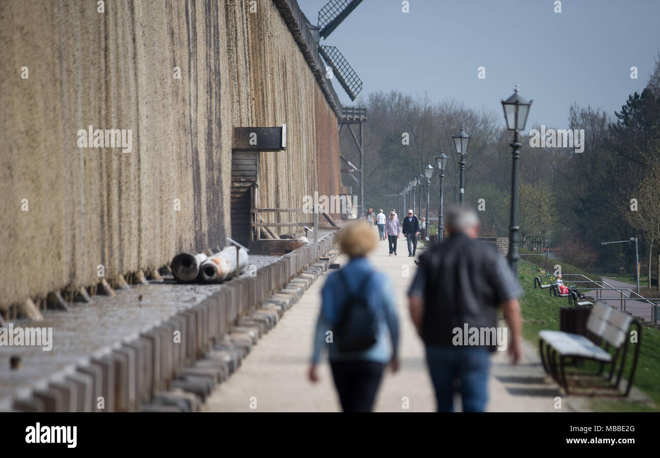 10 April 2018, Germany, Bad Rothenfelde: Pedestrians walk along the graduation house of the state's spa. Photo: Friso Gentsch/dpa Stock Photo