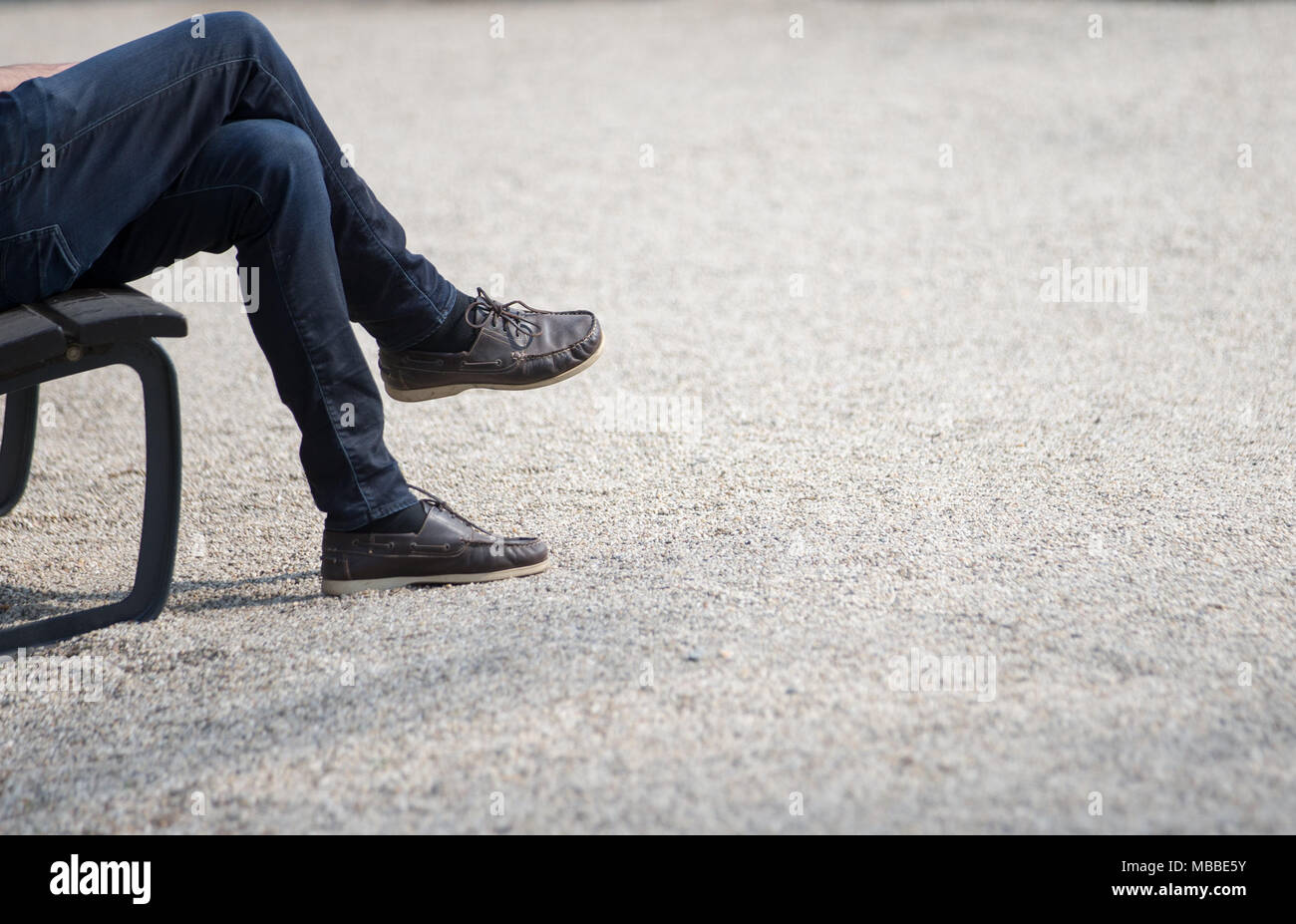 10 April 2018, Germany, Bad Rothenfelde: The crossed legs of a man resting on a bench. Photo: Friso Gentsch/dpa Stock Photo