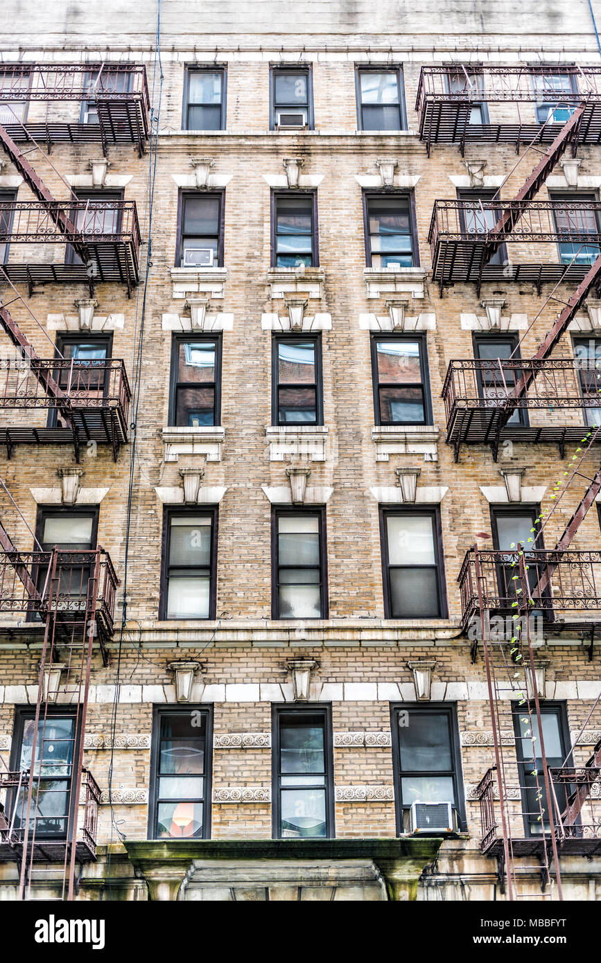 Old apartment condo building exterior architecture in Chelsea, NYC, Manhattan, New York City with fire escapes, windows, ladders Stock Photo