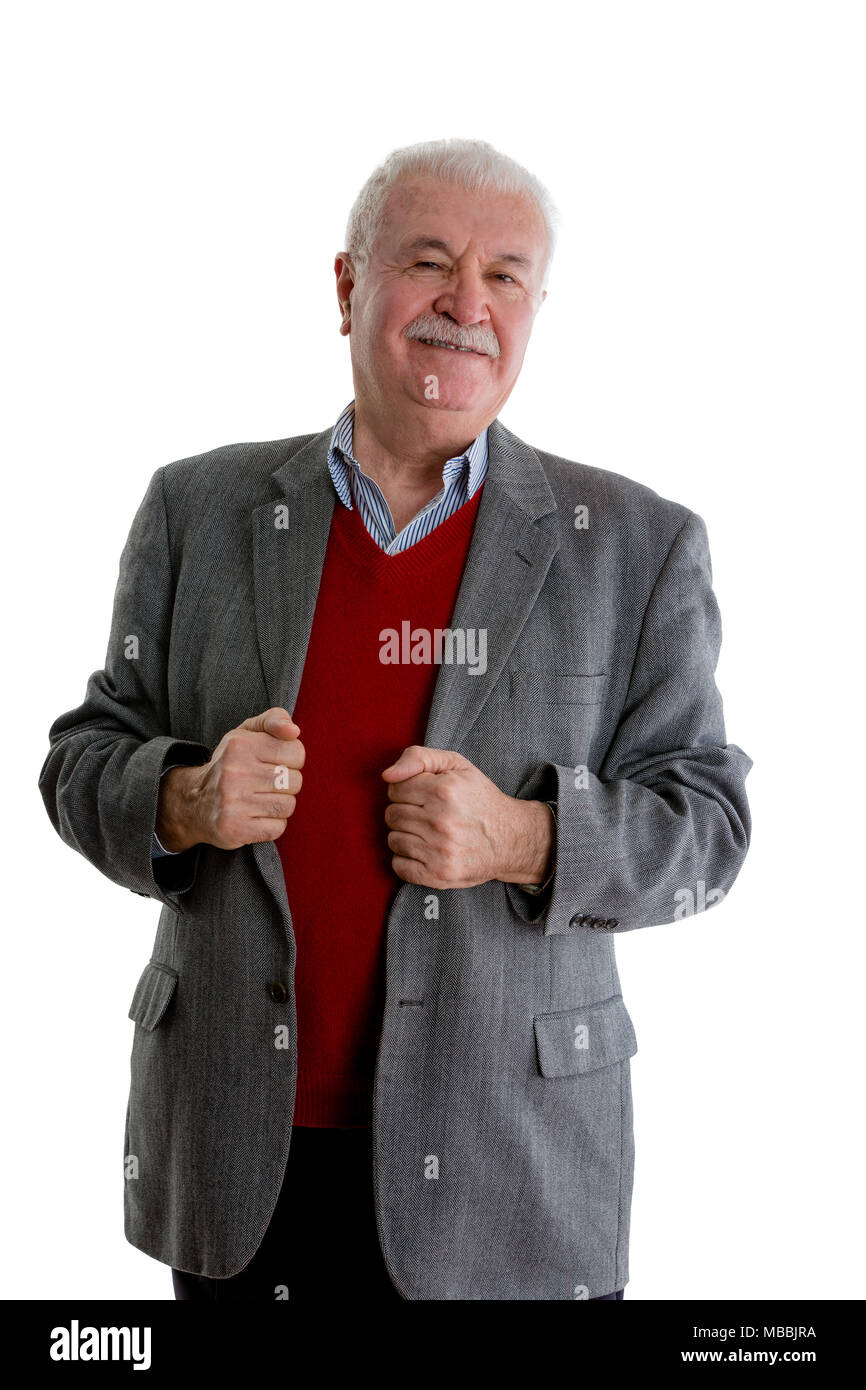 Suspicious senior man looking sceptically at the camera as he stands gripping the lapels of his jacket isolated on white Stock Photo